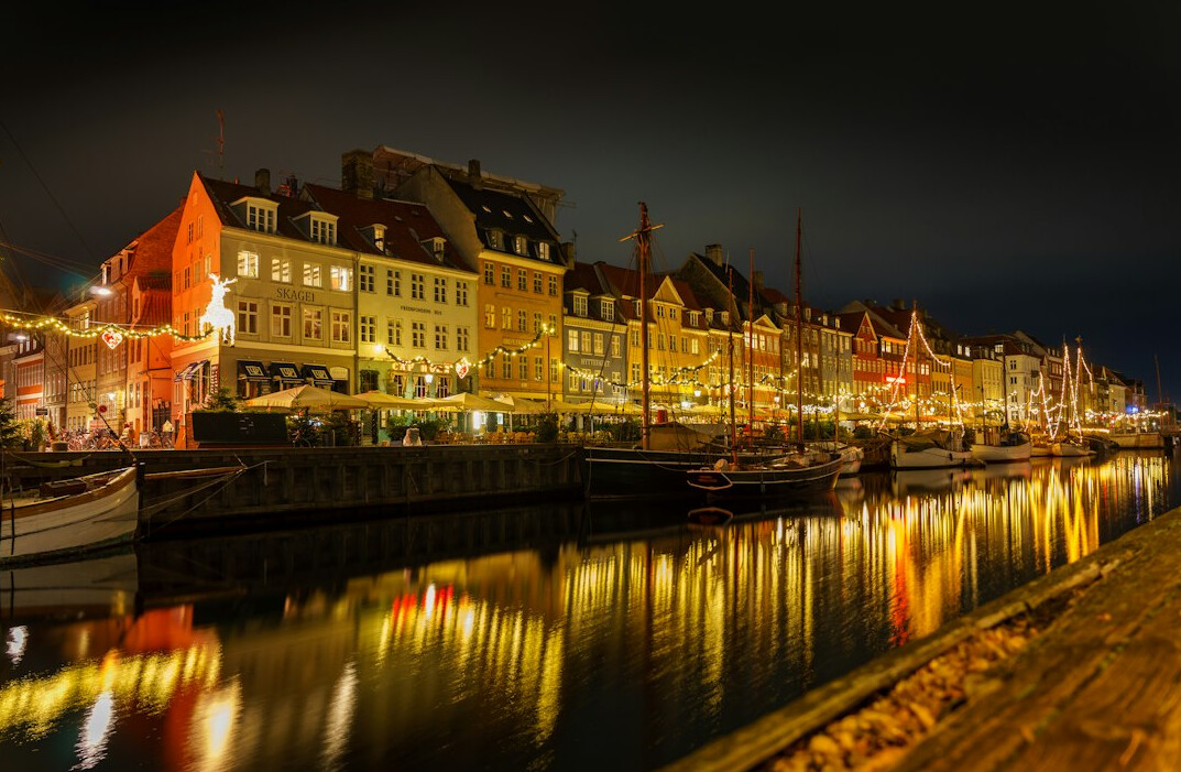 Colorful harbor houses reflected in water in Copenhagen at dusk