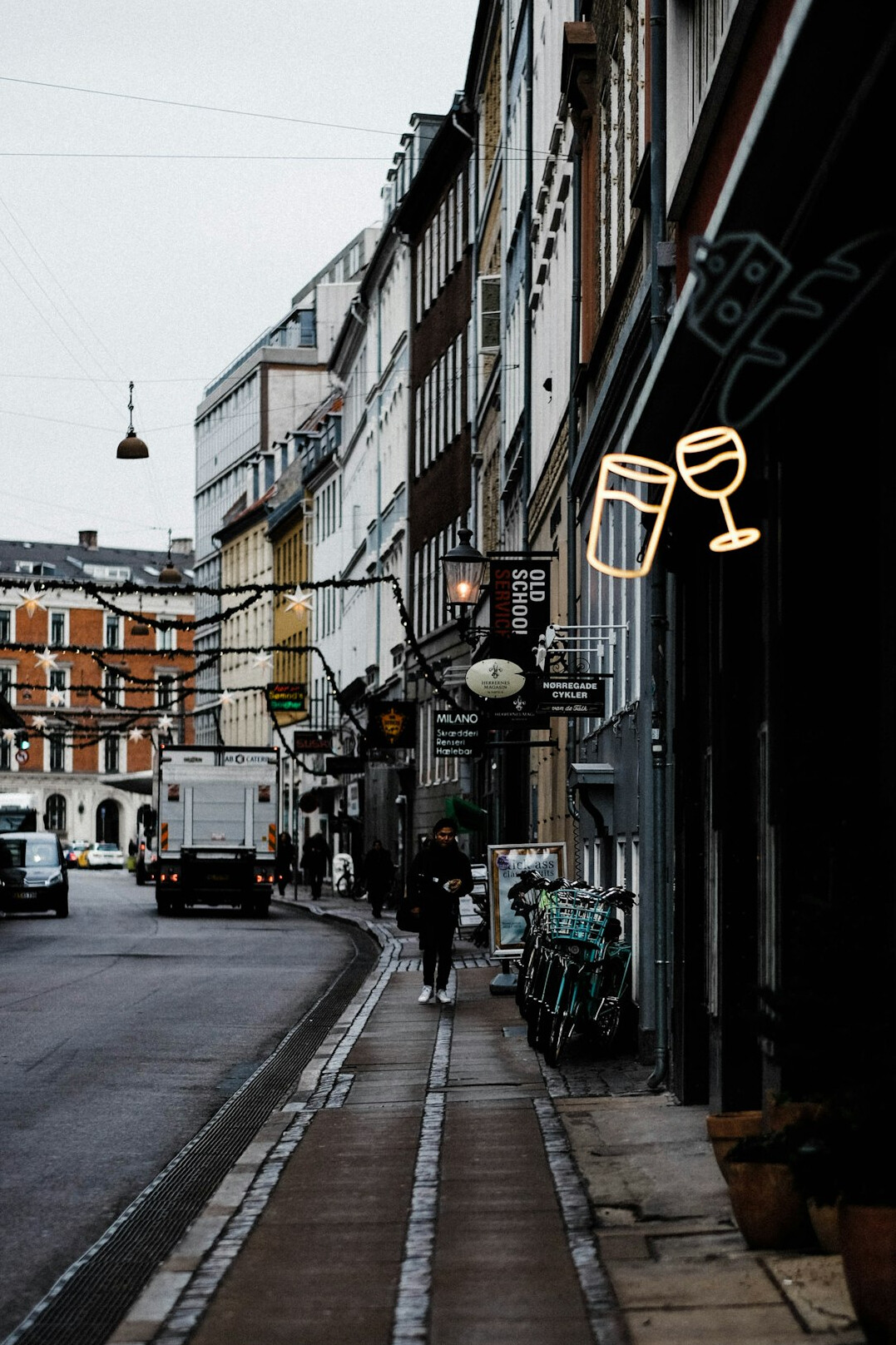 Hands holding a film camera while walking through a Danish street