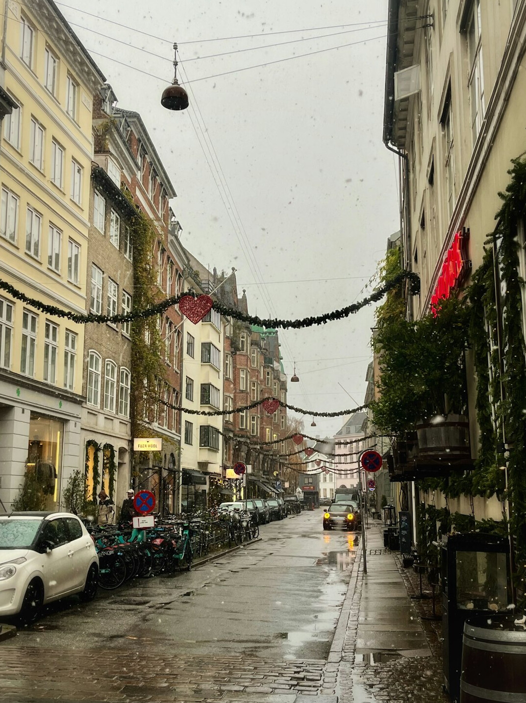 Pedestrian walking with an umbrella on a rainy Danish street