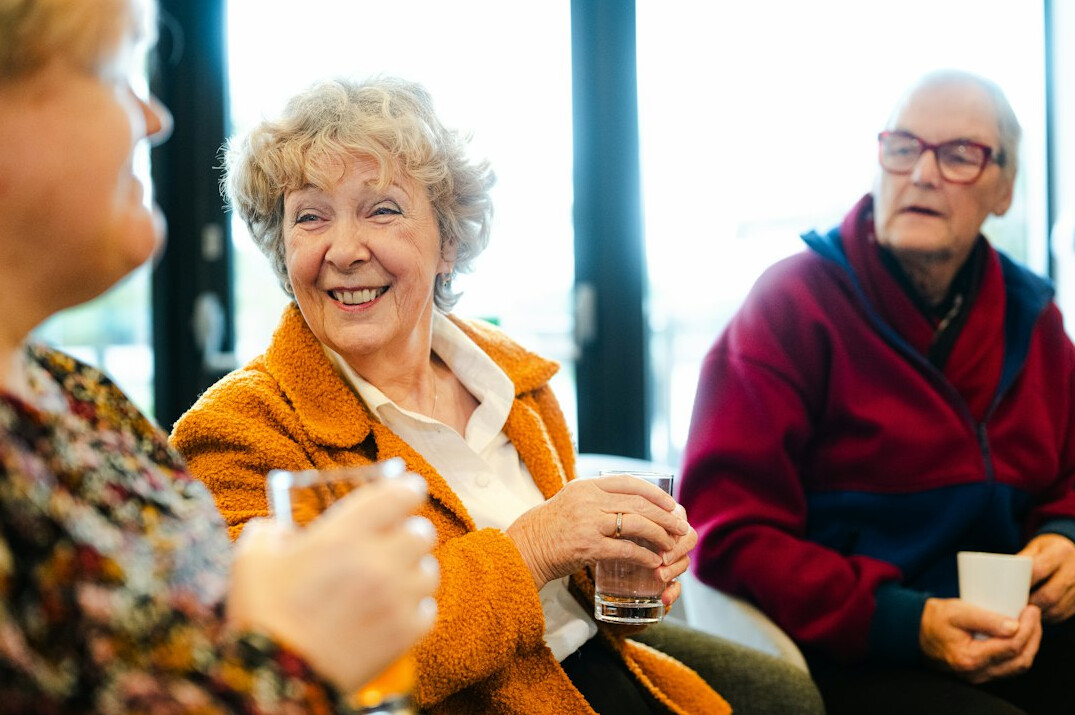 elderly woman smiling with neighbors