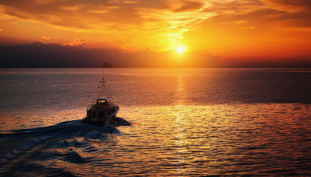 fishing boat returning at sunset